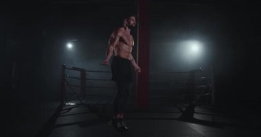 Bir kas vücut ile iyi görünümlü adam çapraz fitness sınıfında egzersizleri yapıyor sert bir ip kullanarak atlama
