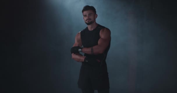 Bodybuilding man portrait standing in front of the camera and posing in a gym class with black background — Stock Video