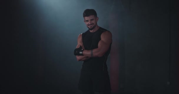 Sehr charismatisch lächelnder großer Sportler, der direkt in die Kamera schaut und in einem Fitnessstudio groß lächelt — Stockvideo