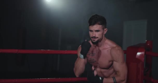 Grande cara olhando na frente da câmera prepare-se para iniciar sua luta de boxe ele faz alguns exercícios para se preparar para o jogo — Vídeo de Stock