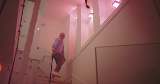 Modern house party atmosphere guy avec les lunettes de soleil dansant dans les escaliers, il a une grande et excitée énergie à la fête — Video