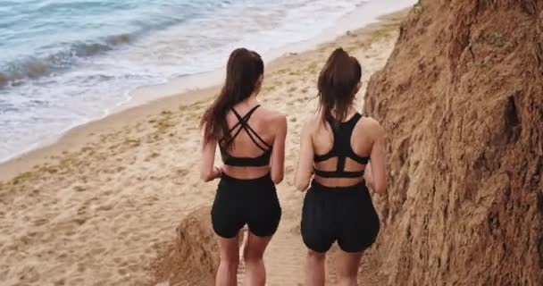 Les deux filles courent les graisses sur les marches de la nature, et courent vers la mer — Video