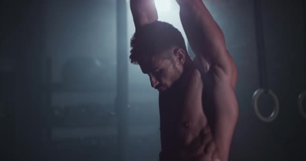 Athletischer Kerl mit perfektem Körper in einer Cross-Fitness-Klasse beim harten Training in einer dunklen Klasse vor der Kamera — Stockvideo