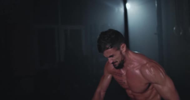 Framför kameran en hård träning på cross fitness klass kille med en boll arbetar intensivt få svettas och koncentreras för att göra mer muskler på magmusklerna — Stockvideo
