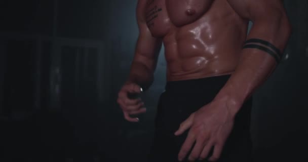 Detailaufnahme eines schweißtreibenden Bauchmuskels in einem dunklen Crosstraining nach einem intensiven Training — Stockvideo