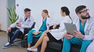 Karizmatik ve iyi ruh hali olan doktorlar malzeme odasında mola veriyorlar. Birlikte bir şeyi analiz ediyorlar.