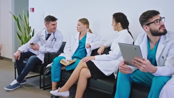 Carismático com um bom humor médicos no hospital na sala de material ter um tempo de pausa eles discutem juntos analisando algo — Vídeo de Stock