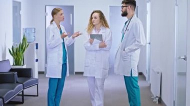 Hastane koridorunda bir hemşire ve iki doktor kameranın önünde hastanın teşhisini ve gelecekteki tedavisini tartışıyor.