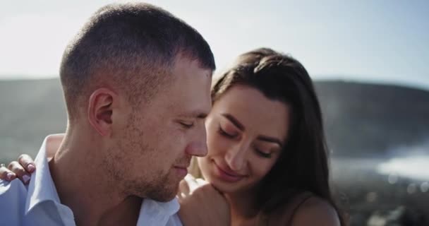 Close-up para a câmera jovem casal atraente ter um momento romântico perfeito juntos na praia ao lado do mar eles se tocando — Vídeo de Stock