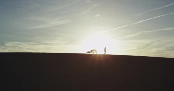 На заході сонця пара дуже роман біжить через великий пляж вони добре проводять час — стокове відео