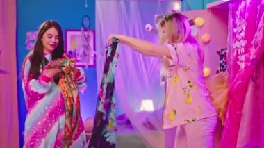 Güzel görünümlü iki genç bayan komik pijamalı eğlenceli bir pijama gecesi geçiriyorlar. Gardırobu açıp komik giysiler giyip oyun oynuyorlar.