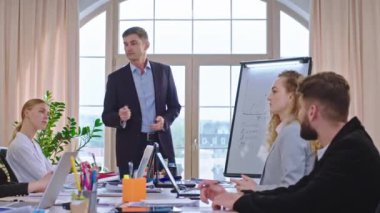 Toplantı odasında iş adamı, beyaz tahtanın üzerindeki ofis müdürüne yeni bir iş planı sundu. Çok heyecanlıydı.