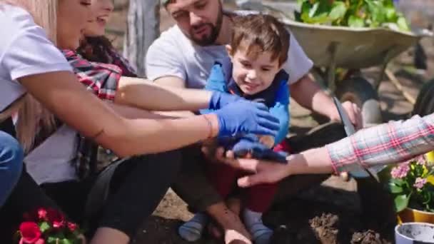 정원 한 가운데서 큰 팀 이 손을 잡고 행복하게 일어서는 것처럼 정원 밖에서 정원에서 일을 마치고 큰 가족들에게 미소짓고 있는 모습 — 비디오