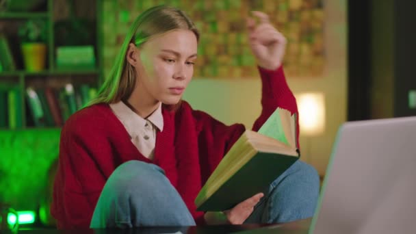 Carismática hermosa estudiante en la biblioteca estudiando algo leyendo algunos libros y hacer la cara concentrada mientras lee — Vídeo de stock