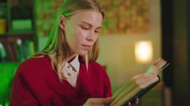 Kameraman öğrencinin önünde. Evde kitap okuyor. Kolej projesiyle ilgili bir şeyler yazıyor.