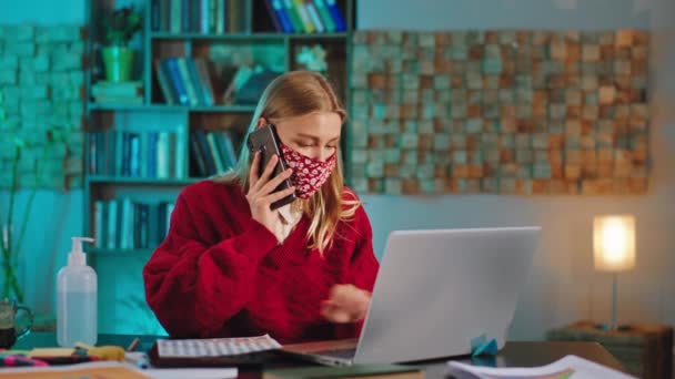 Fiatal lány diák csinál neki főiskolai projekt otthon ő használja az okos telefon beszélgetni más kollégákkal, hogy tudja, néhány más információ — Stock videók