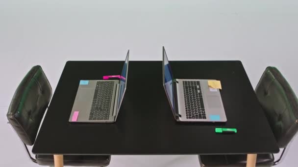 Detailní záběr na kameru v bílém studiovém kancelářském stole se dvěma notebooky a papírovými samolepkami na noteboocích — Stock video