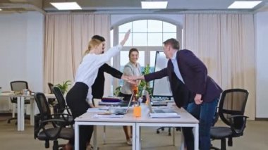 Seminerin çoklu etnik çeşitlilikte büyük bir ofisinde el ele verip iyi bir takım ruhu hissediyorlar.