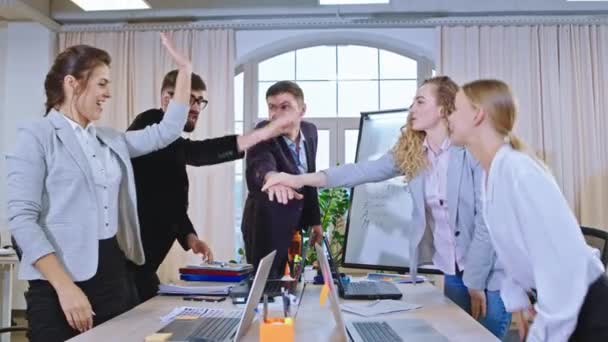 I et moderne kontor i slutningen af uddannelsesseminaret alle kontorarbejdere multietnisk sammenføjning hænder sammen holdånd – Stock-video