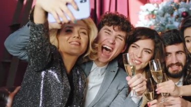 Noel şeylerinde selfie zamanı. Bir grup işçi gülümsüyor ve birlikte poz veriyor. Doğrudan akıllı telefona bakıyorlar.