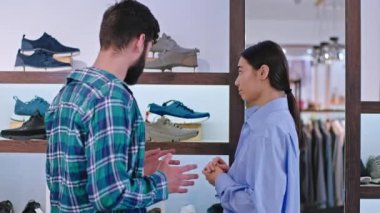 Asyalı genç bayan danışman ve ayakkabı dükkanındaki çekici erkek müşteri hangisinin daha iyi olduğunu tartışıyorlar. ARRI Alexa Mini 'de çekilen