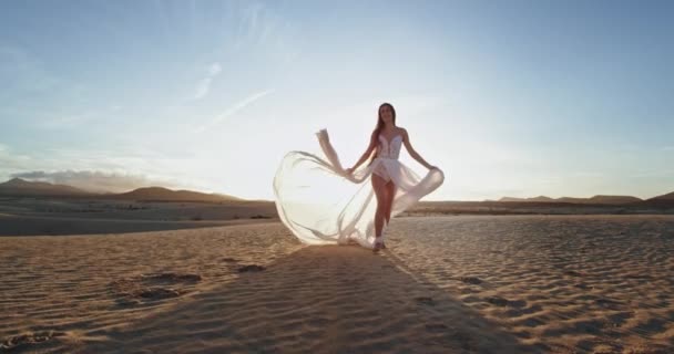 Delante de la cámara caminando hermosa dama al atardecer que sostiene su vestido romántico. mociones lentas — Vídeo de stock