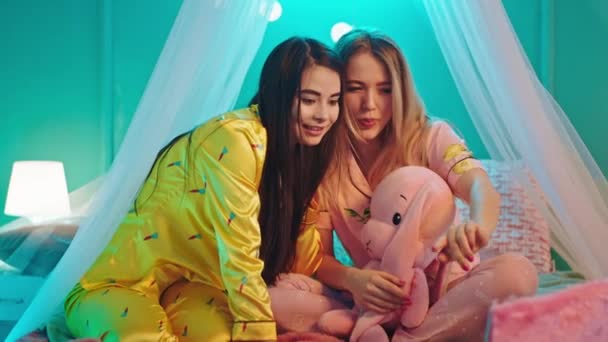Carismáticos dos amigos guapas mujeres jóvenes tienen una fiesta de pijamas juntos en un precioso pijama que pasan un buen rato — Vídeos de Stock