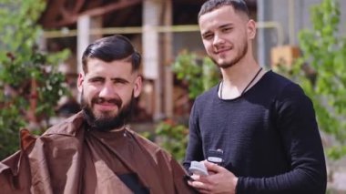Kameranın önünde, bahçedeki iki adam güneşli bir günde elektronik makasıyla saçlarını kesmeye başlıyorlar. ARRI Alexa Mini 'de çekilen
