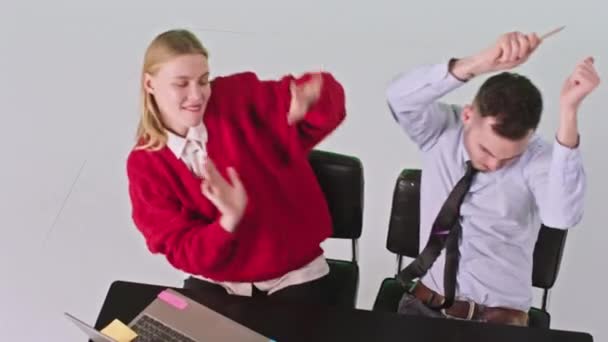 Uśmiechnięta duża charyzmatyczna pracownica biurowa i mężczyzna tańczący i cieszący się czasem w swoim miejscu pracy w dużym białym studio — Wideo stockowe