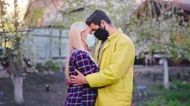 낭만적 인 커플 과 격리 구역에서 집에 있는 남자는 코로나 바이러스로 인해 서로 보호 마스크를 쓰고 화가 나서 서로를 지원하고 있습니다. — 비디오
