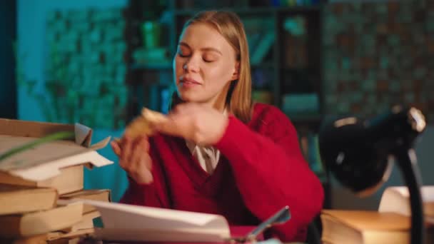 Studera tid i biblioteket vacker student skriva lite information om skrivmaskinen och äta lite pizza på natten — Stockvideo