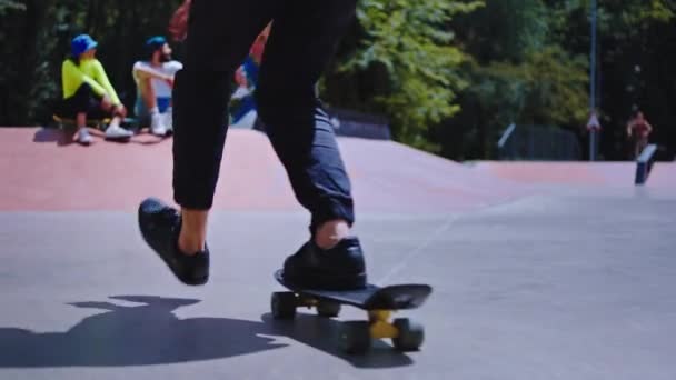 Ragazzo felice ed eccitato è venuto al suo gruppo di amici in un parco skate urbano si incontrano tutti insieme socializzare prima di iniziare a skateboard. 4k — Video Stock