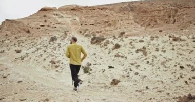 Gözlüklü yakışıklı adam muhteşem manzarada koşuyor. Yalnız gezmekten hoşlanıyor.