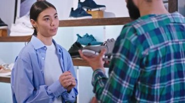 Büyük bir ayakkabı mağazasında çekici bir Asyalı kadın satıcının, müşterisi için mükemmel ayakkabıları bulmak istediği bir konsültasyonu var. 4k