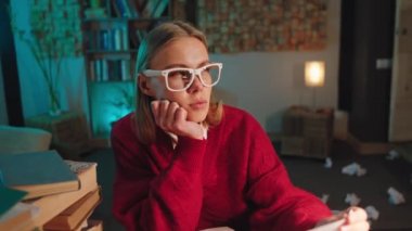 Kütüphanede üniversite projesini yapan genç ve güzel bir bayan öğrenci notları yazmak için eski bir daktilo kullanıyor.