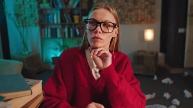 Düşünen yüzlü harika bir bayan üniversite projesi için kütüphanedeki daktiloda bazı belgeler yazıyor.