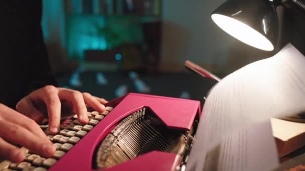 Dans le bibliothécaire utilisant une machine à écrire rose rétro pour taper du texte sur le papier