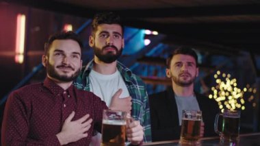 Spor barındaki çekici adamlar, maç finalini televizyon karşısında bira içerken konsantre ve duygusal bir şekilde izliyorlar. 4k