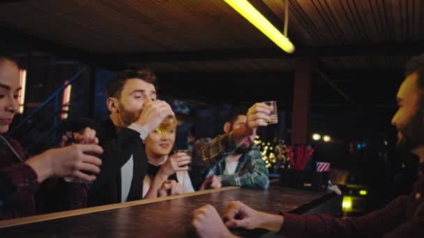 Jolies dames et beaux mecs profitant de l'heure du soir dans un bar moderne ils boivent quelques cocktails se sentent détendus puis heureux de rentrer chez eux barman commencer à nettoyer le lieu de travail — Video