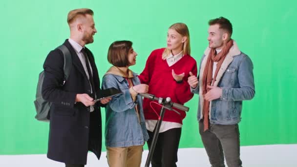 Gran grupo de estudio de fondo verde de amigos carismáticos multiétnicos socializando que de pie frente a la cámara sosteniendo scooter eléctrico — Vídeos de Stock