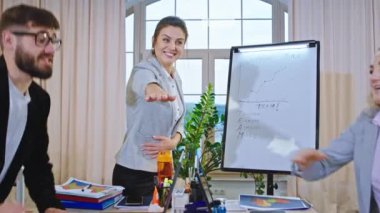 İyi görünümlü olgun kadın takım lideri eğitim seminerini el ele tutuşarak bitirir sonra da heyecanlı bir şekilde alkışlar.