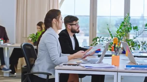 Em um escritório moderno com uma vista panorâmica grupo de manjedouras e trabalhadores de escritório fazem um plano de negócios estratégico e eles discutem algumas ideias de liderança. 4k — Vídeo de Stock