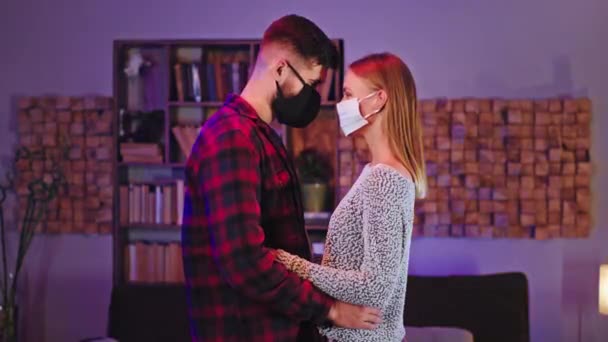 Pár zamilovaný do ochranné masky před kamerou zůstat rozrušený hlava hlavy při pohledu na sebe doma v karanténní koncepci Covid-19 — Stock video