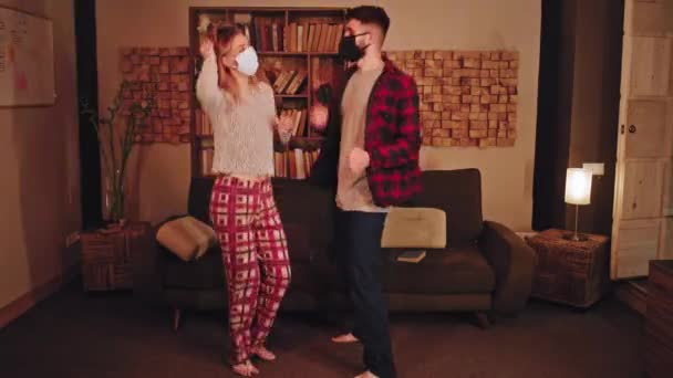 一对快乐迷人的夫妇在一起，穿着睡衣跳舞，呆在家里，享受检疫验尸2019的快乐时光 — 图库视频影像