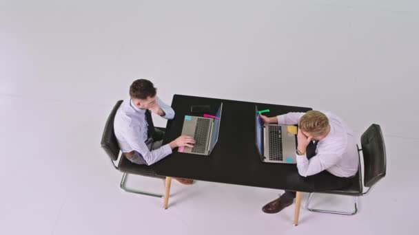 Επιχειρηματική ιδέα δύο διευθυντές γραφείου άνδρες στο στούντιο λευκό φόντο που εργάζονται επικεντρώθηκε σε φορητούς υπολογιστές τους πληκτρολογώντας κάποια έγγραφα — Αρχείο Βίντεο