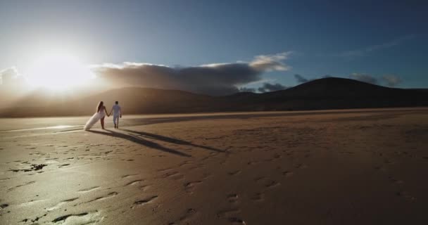 Dame et le gars se serrant dans leurs bras au bord de la mer, ils marchent à travers la plage de sable belle vue sur le paysage. 4k
