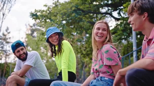 Krásné dámy s dokonalým úsměvem a atraktivní kluci mají diskutovat v moderním skate parku, které socializuje a tráví dobrý čas spolu nosit stylové oblečení — Stock video