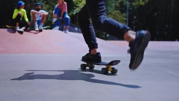 Un bel ragazzo su uno skateboard di buon umore è venuto al suo gruppo di amici hipster in un parco di pattinaggio urbano si sono seduti sul pavimento riunione tutti insieme prima di iniziare a cavalcare su uno skateboard — Video Stock