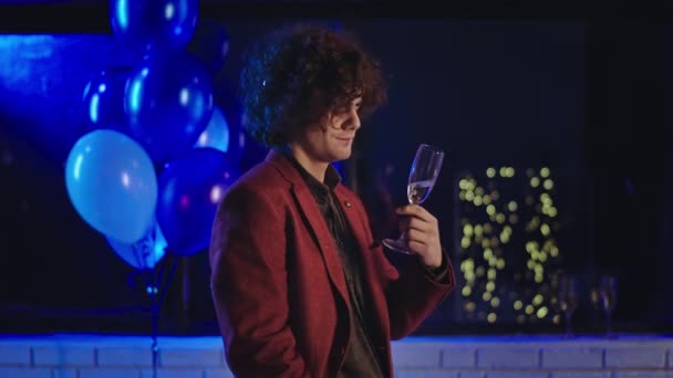 Joven estudiante en la fiesta carismático buscando disfrutar de la noche bebe un poco de vino espumoso y se siente relajado — Vídeos de Stock