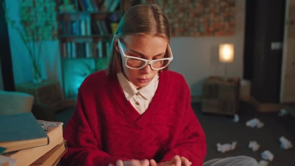 В темном офисе умная блондинка в очках печатает документы на пишущей машинке, а затем карандашом вносит некоторые изменения. — стоковое видео